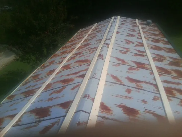 Rusted metal roof panels with new wood purlins before replacement — Storm Damage Roof Repair in Saint Thomas by Roofing Brothers