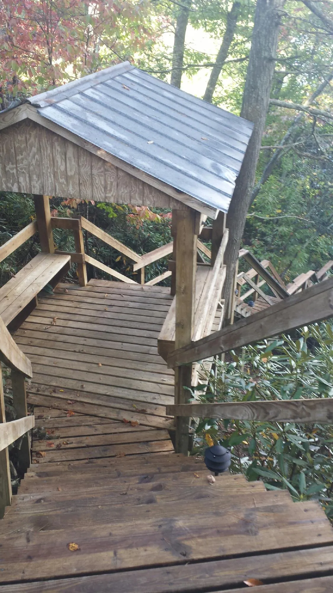 Metal roofed shelter over wooden steps on a wooded walkway — Skylight Repair & Installation work by our crew in Saint Thomas
