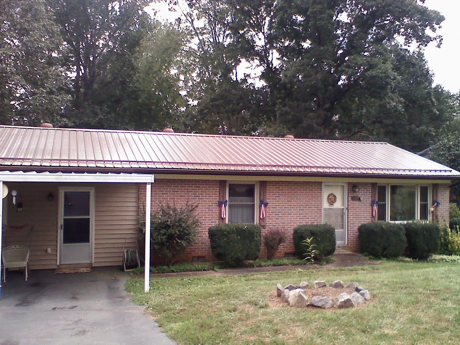 Bronze metal roof and carport on a brick ranch home — Roof Repair work by our crew in Saint Thomas